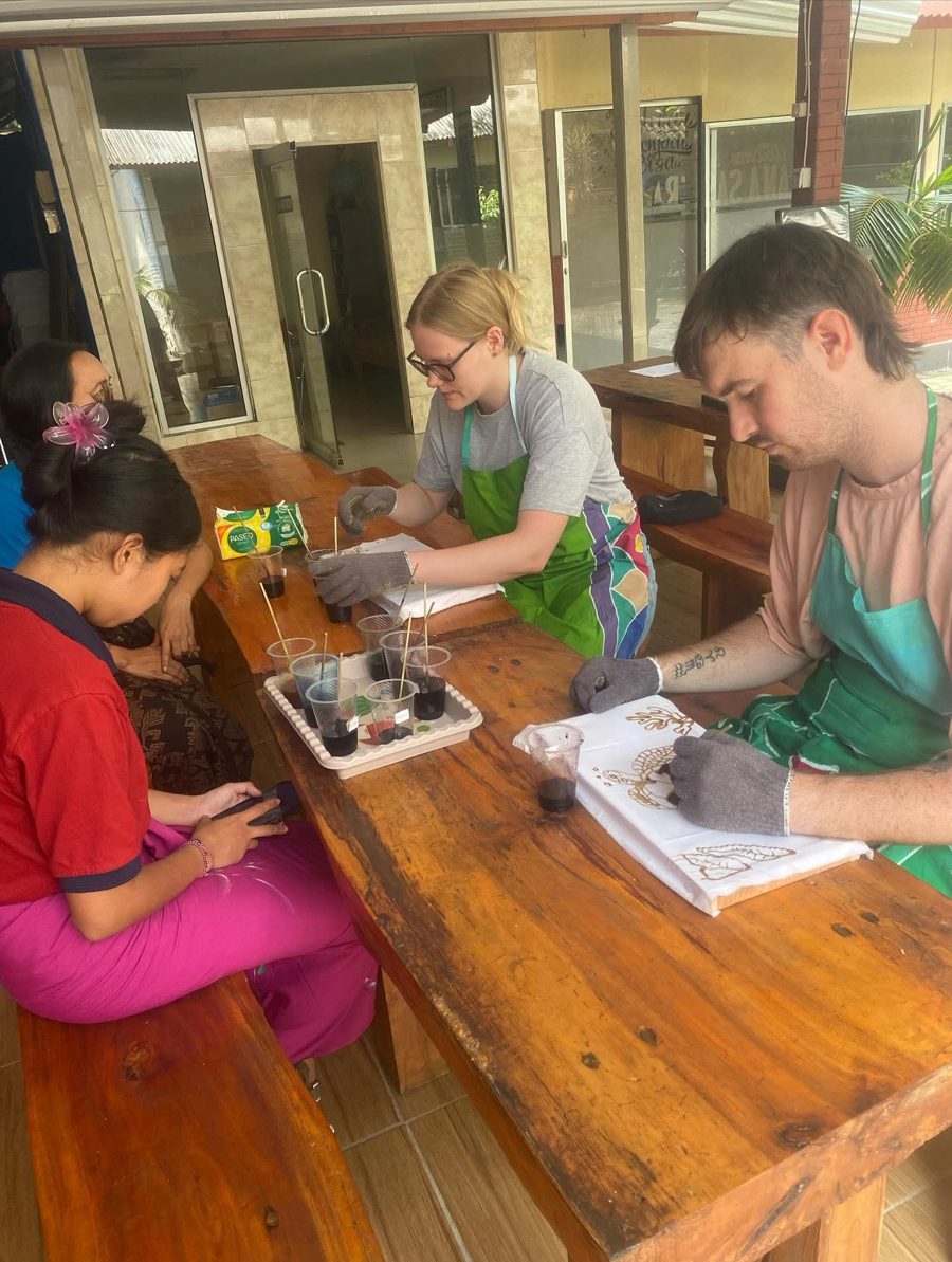 Tourists learning batik techniques closely with an instructor