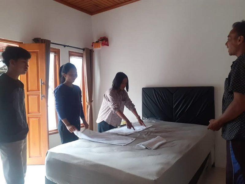 Students learning professional bed-making as part of housekeeping training