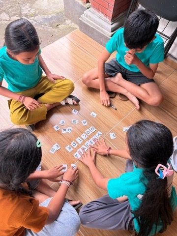 Students playing a letter-tile word game as part of after-school English lessons